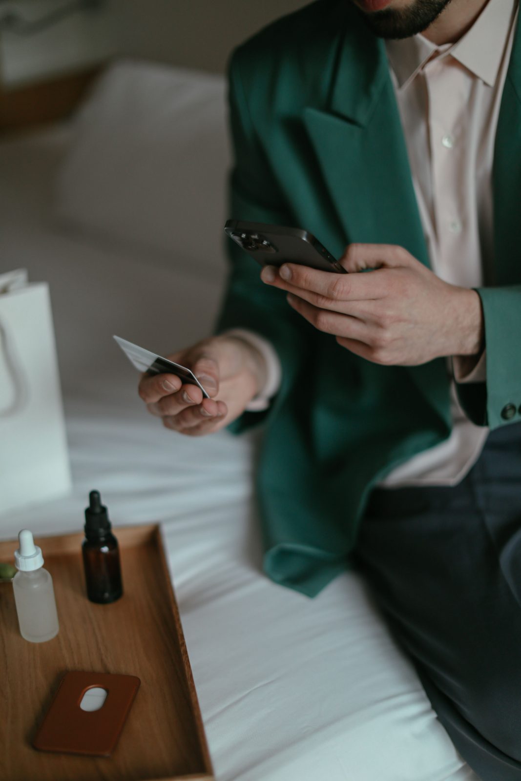 Homem com o celular em uma mão e o cartão bancário na outra