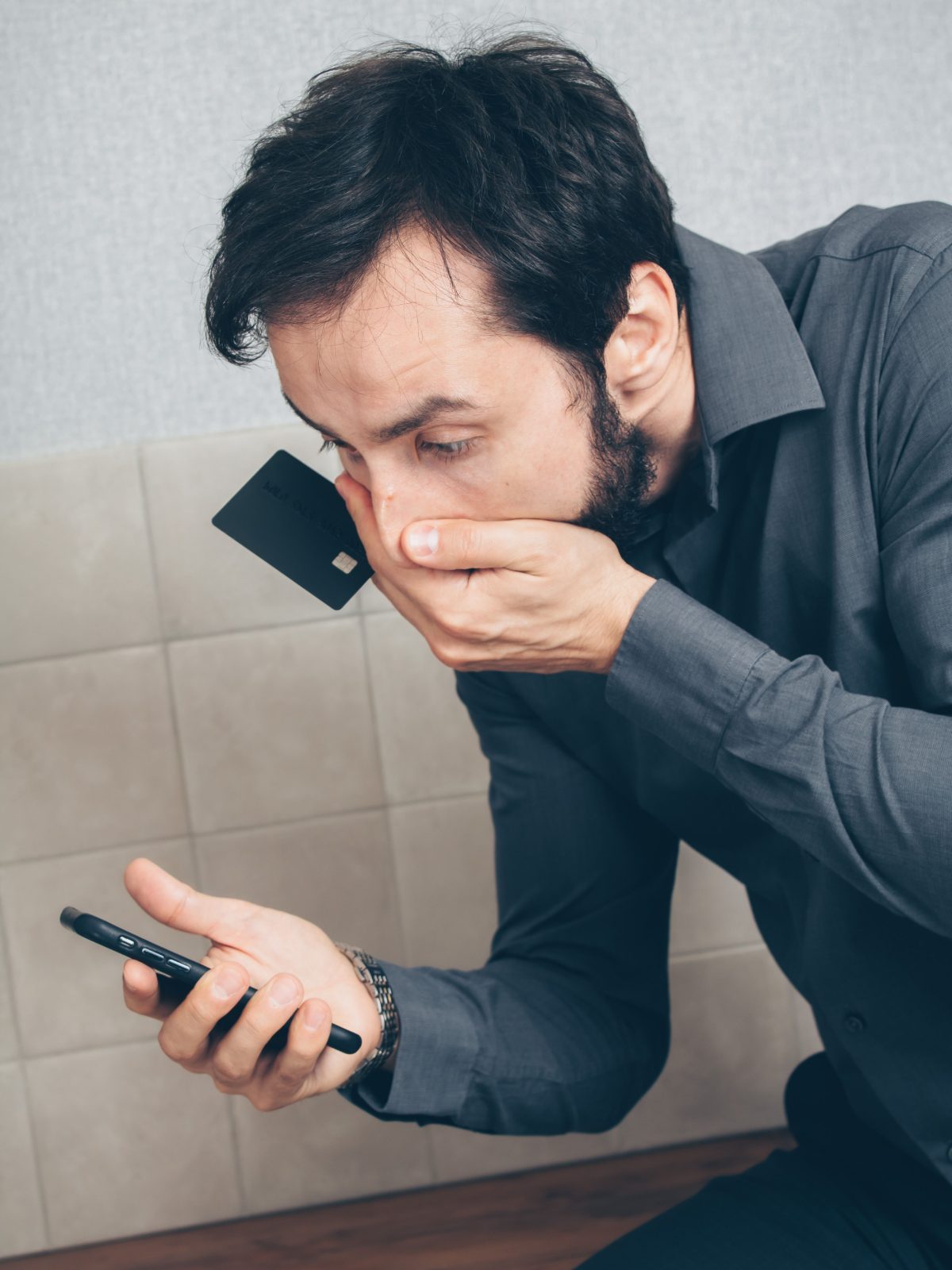 Homem preocupado ao telefone segurando cartão