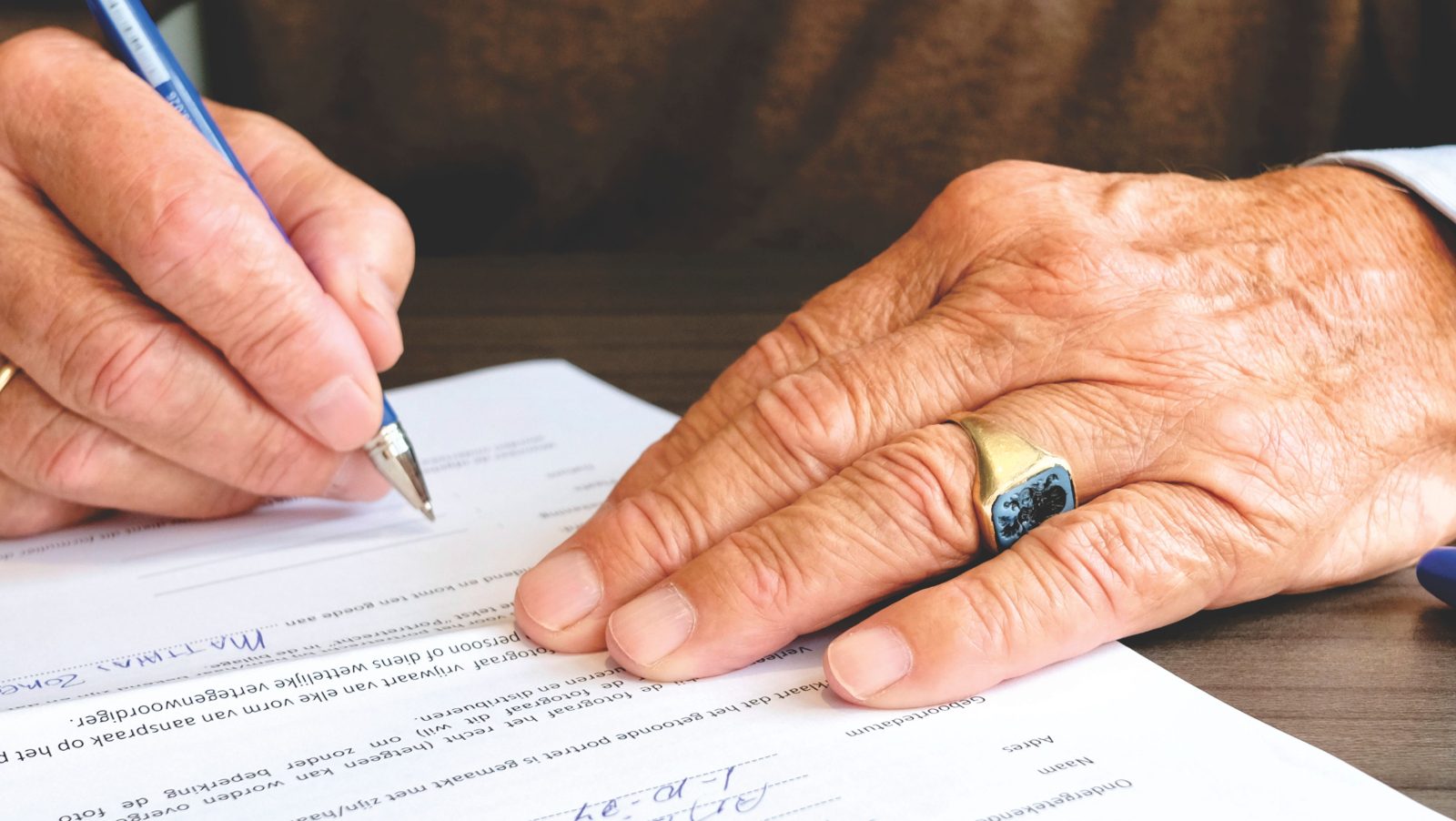 Mãos assinando um documento