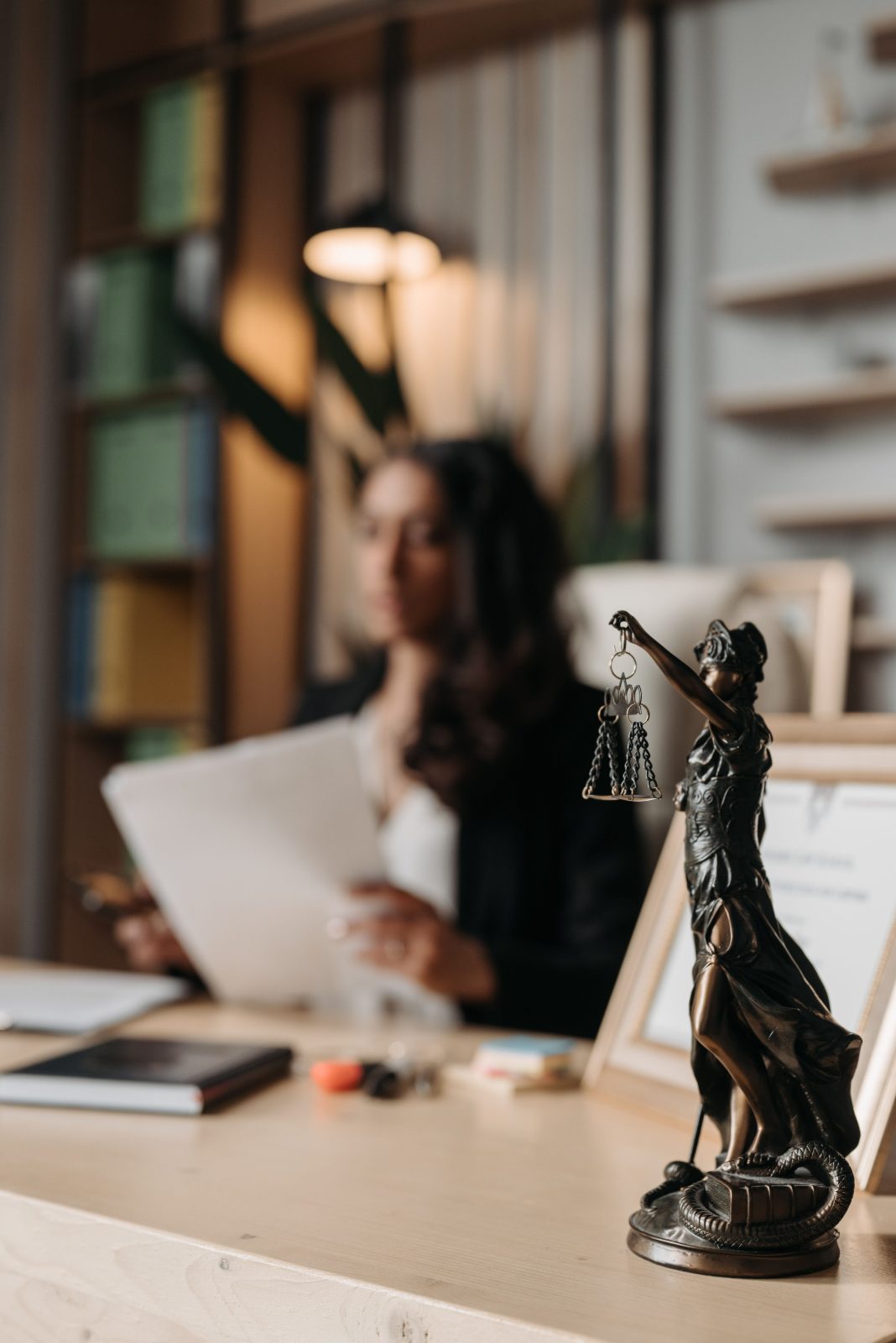 Estatueta da Justiça sobre a mesa de um escritório de advocacia